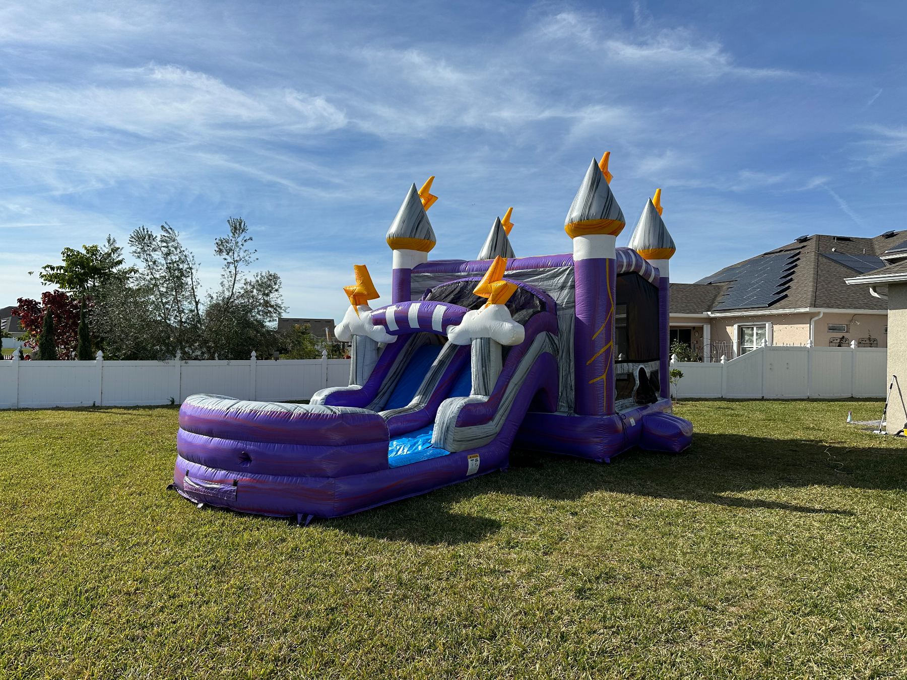 Lightning purple castle with silver towers and lightning bolts in a backyard
