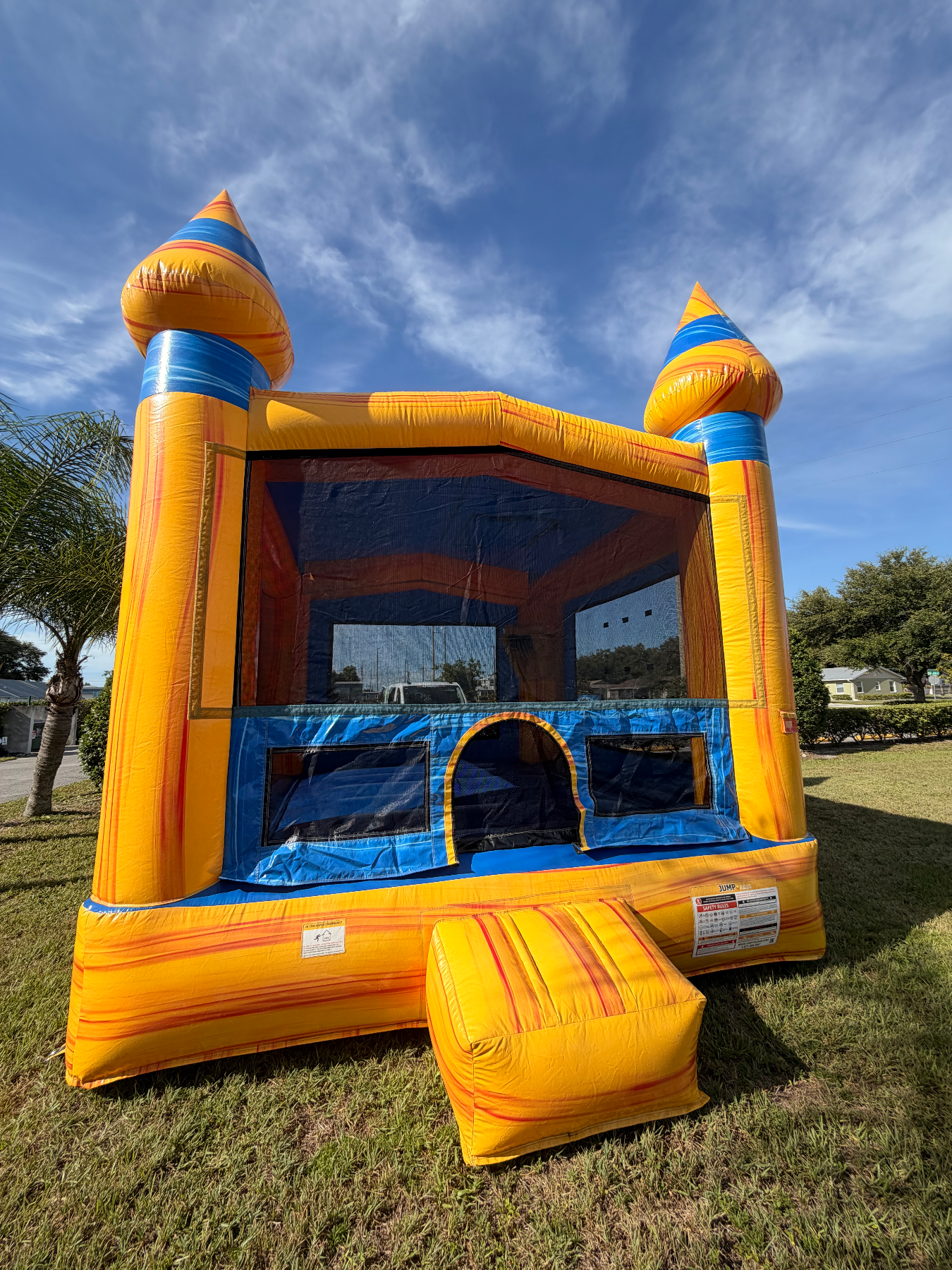 Front of Volcano's yellow and blue bounce house and rounded entry step
