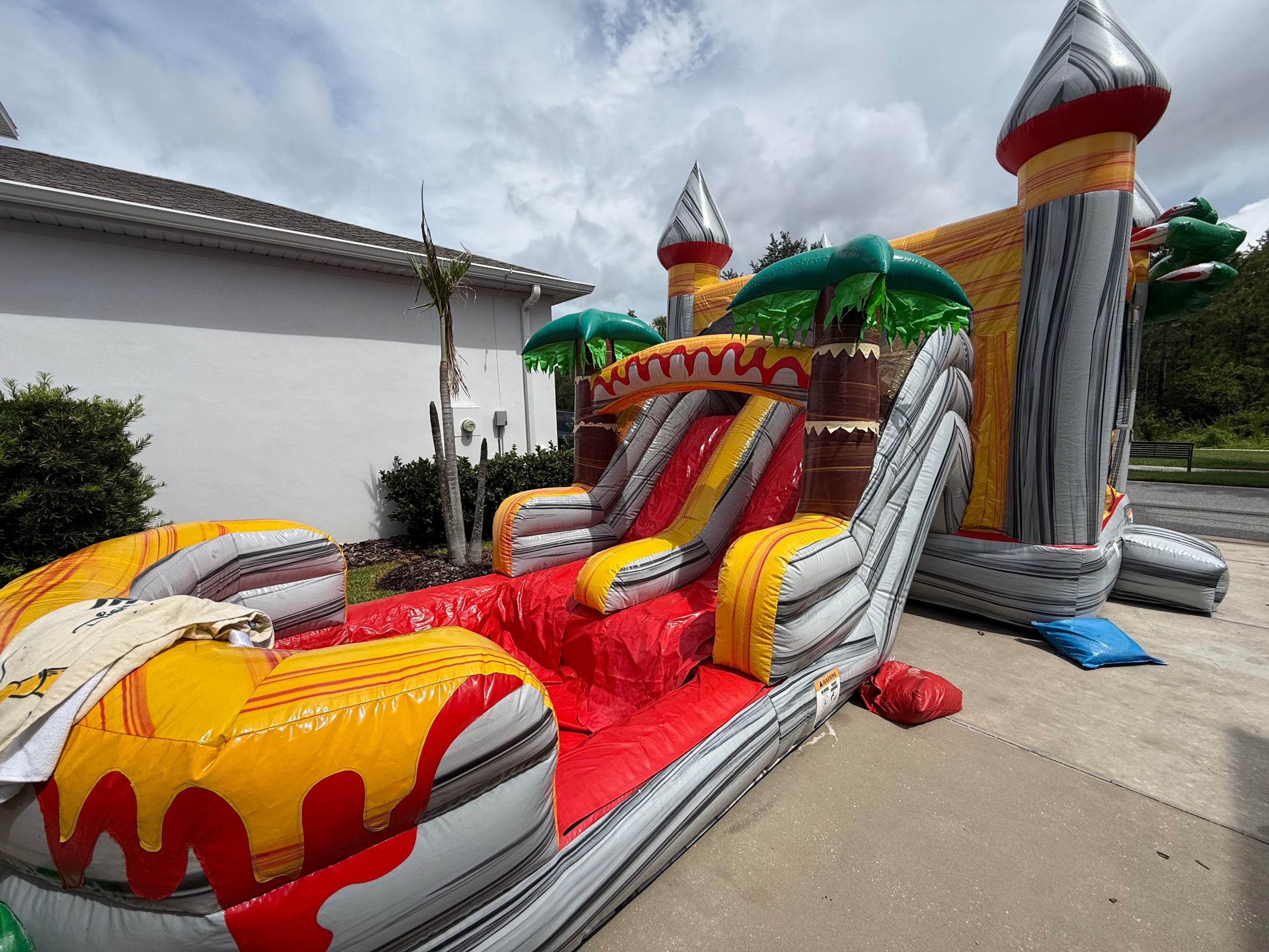 Dino red and yellow slide lanes ending in a dinosaur-mouth splash pool