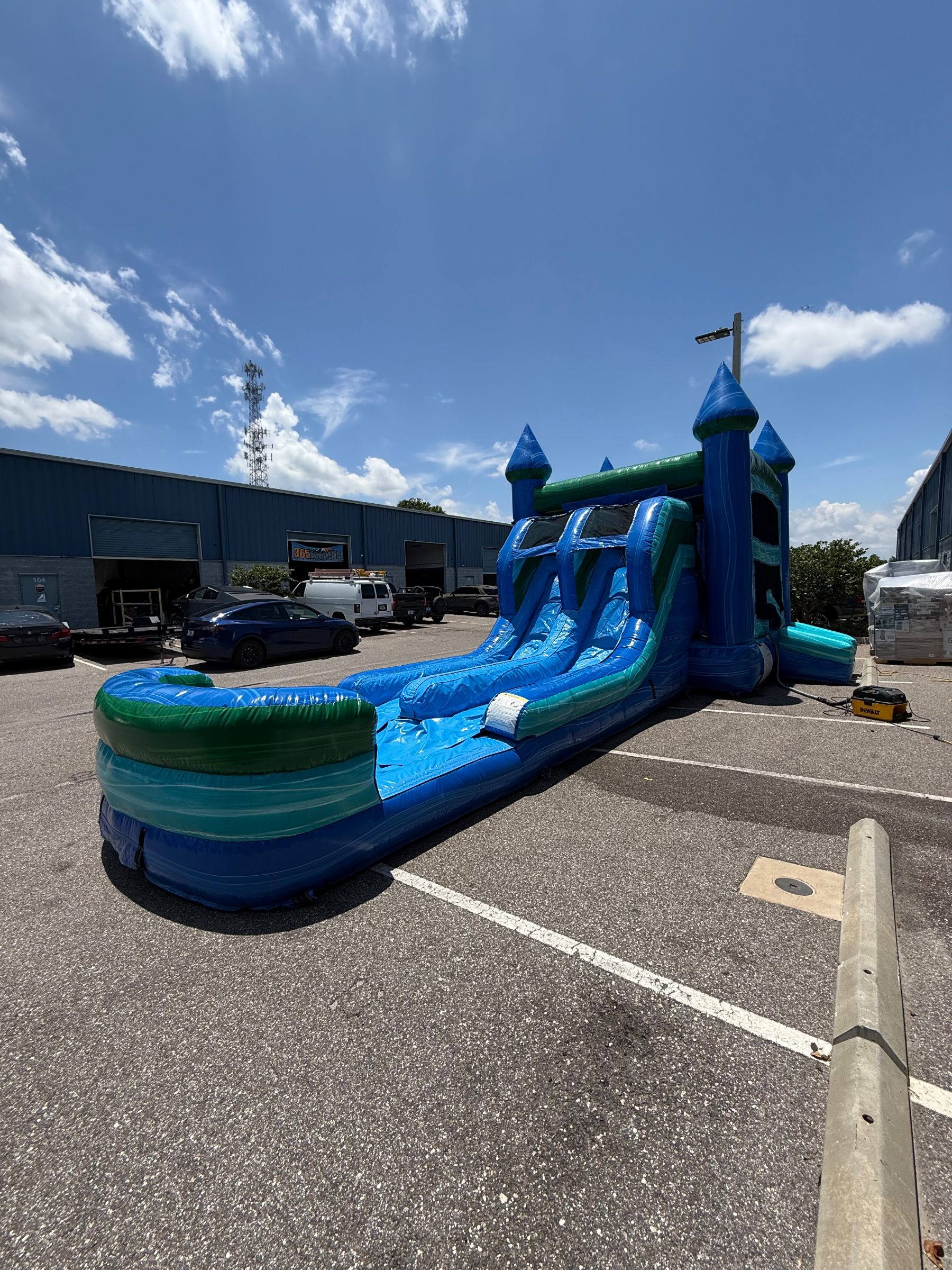 XL Noah's Ark double slide and bounce house on pavement beside a building