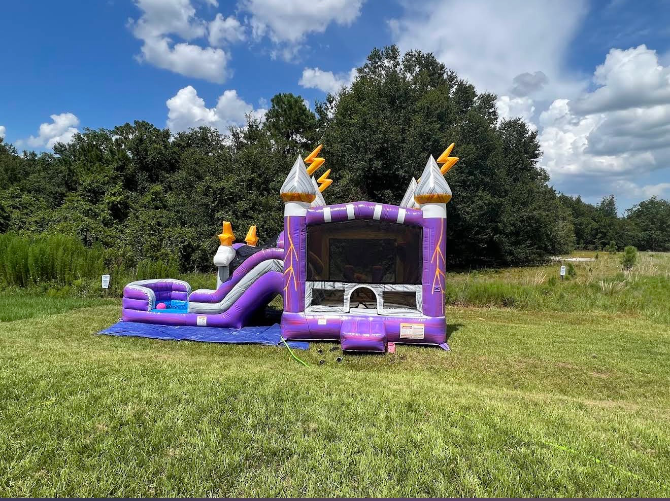 Purple Lightning bounce house and slide with silver towers and yellow lightning bolts