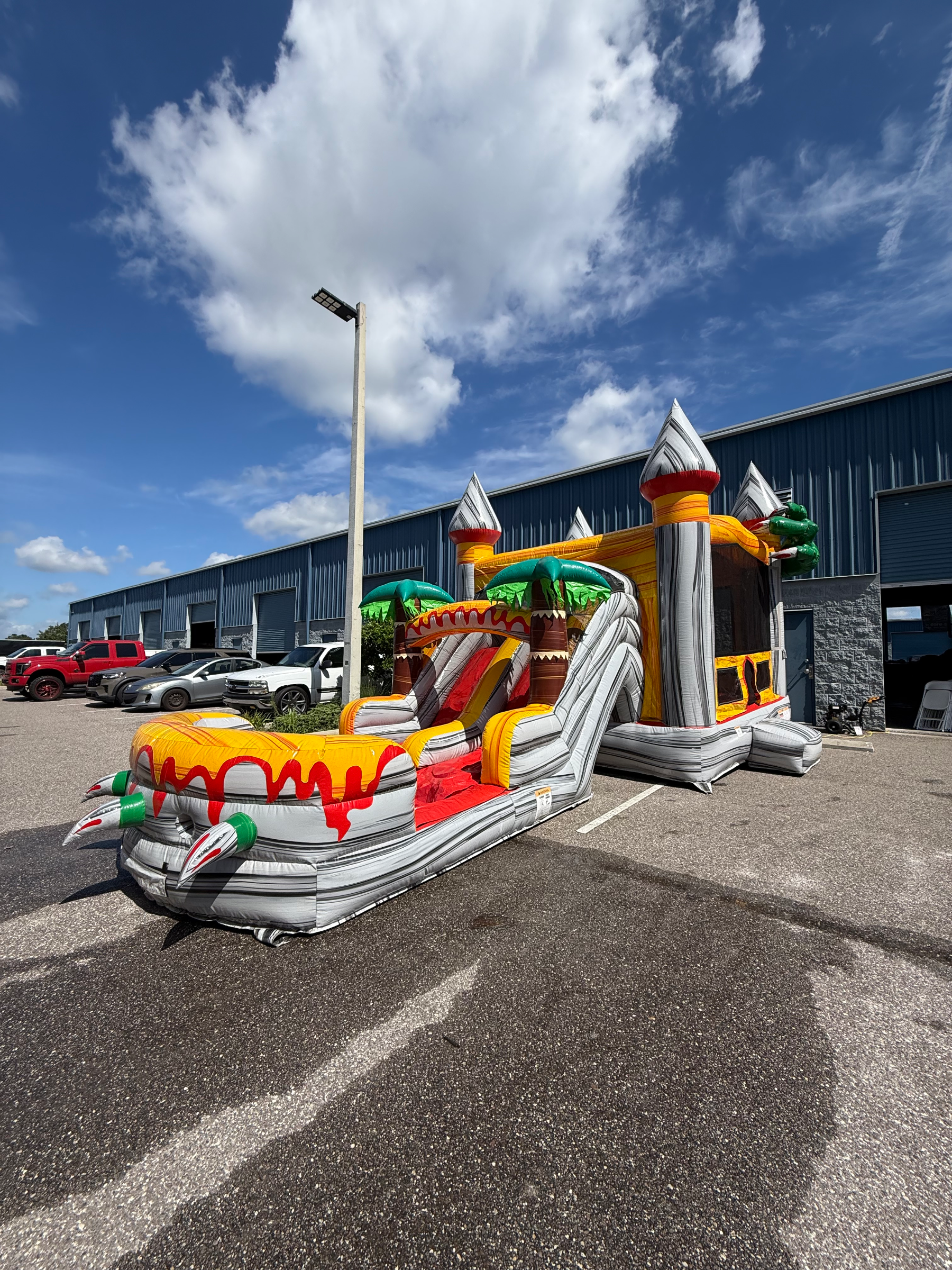 Dino double slide lanes and dinosaur-shaped splash landing outside an event building