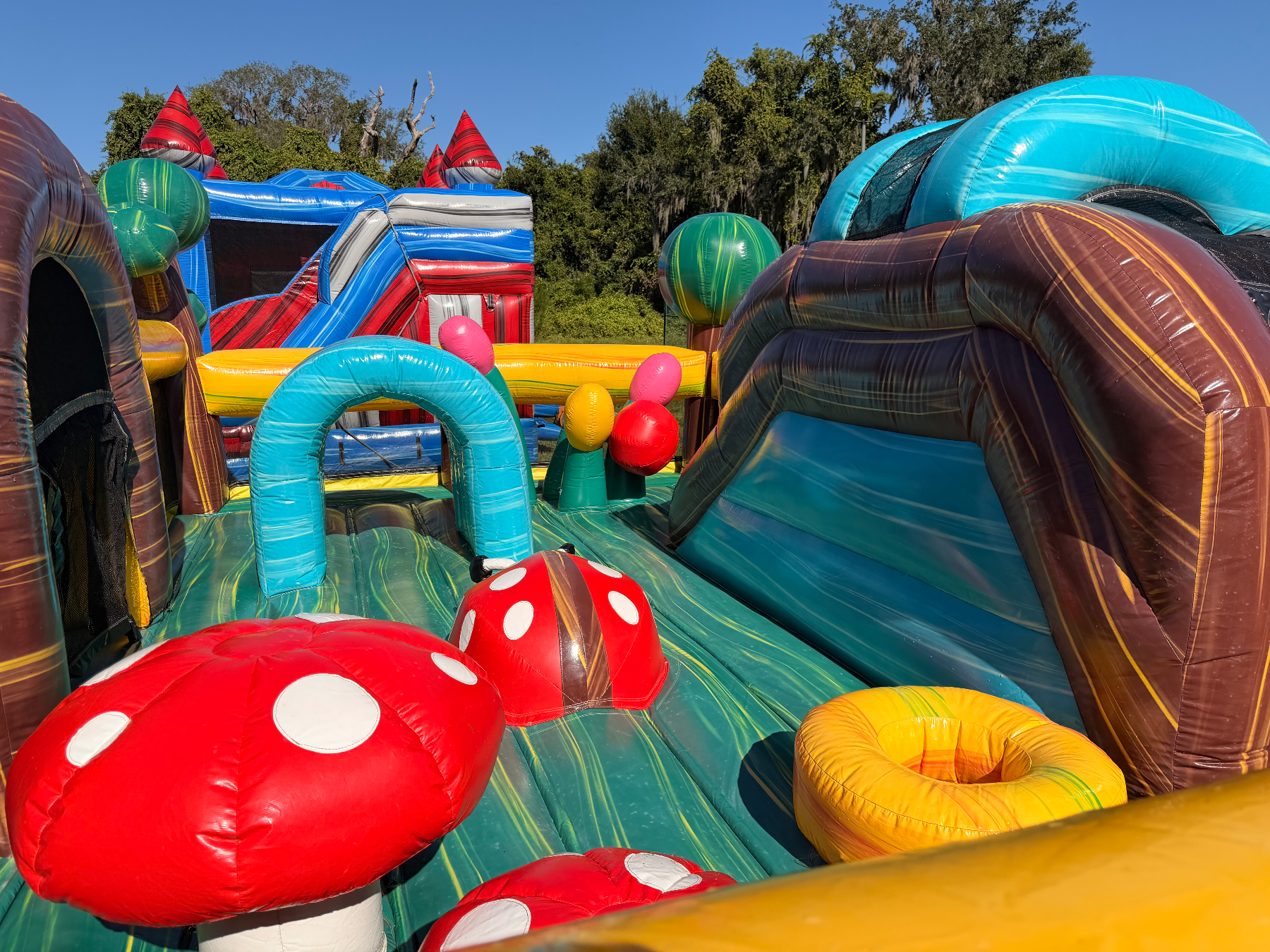 Inside toddler inflatable showing mushroom obstacles and small arched tunnel