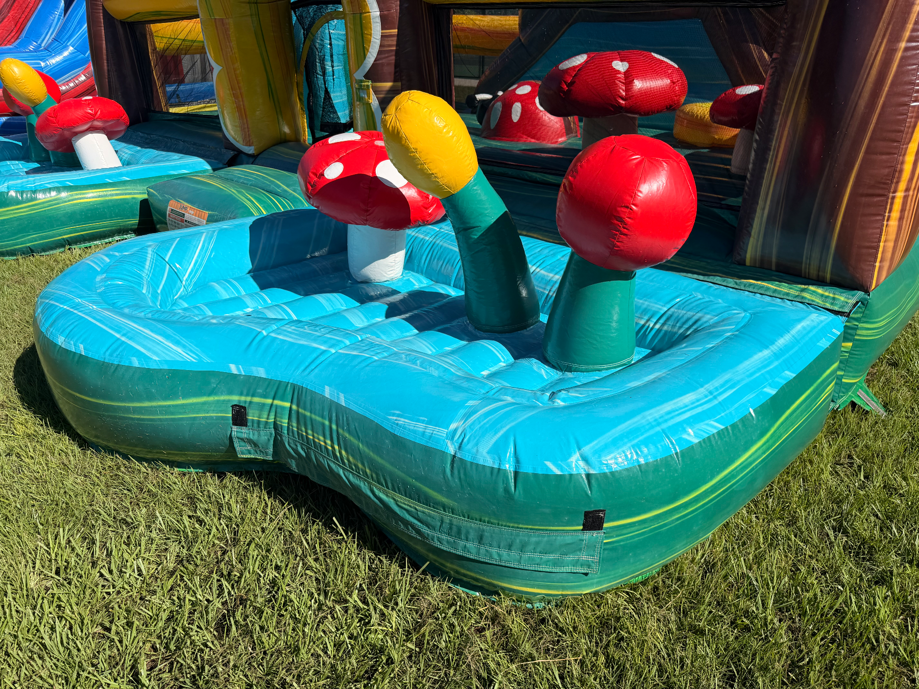Close view of turquoise toddler play bay and red mushroom obstacles