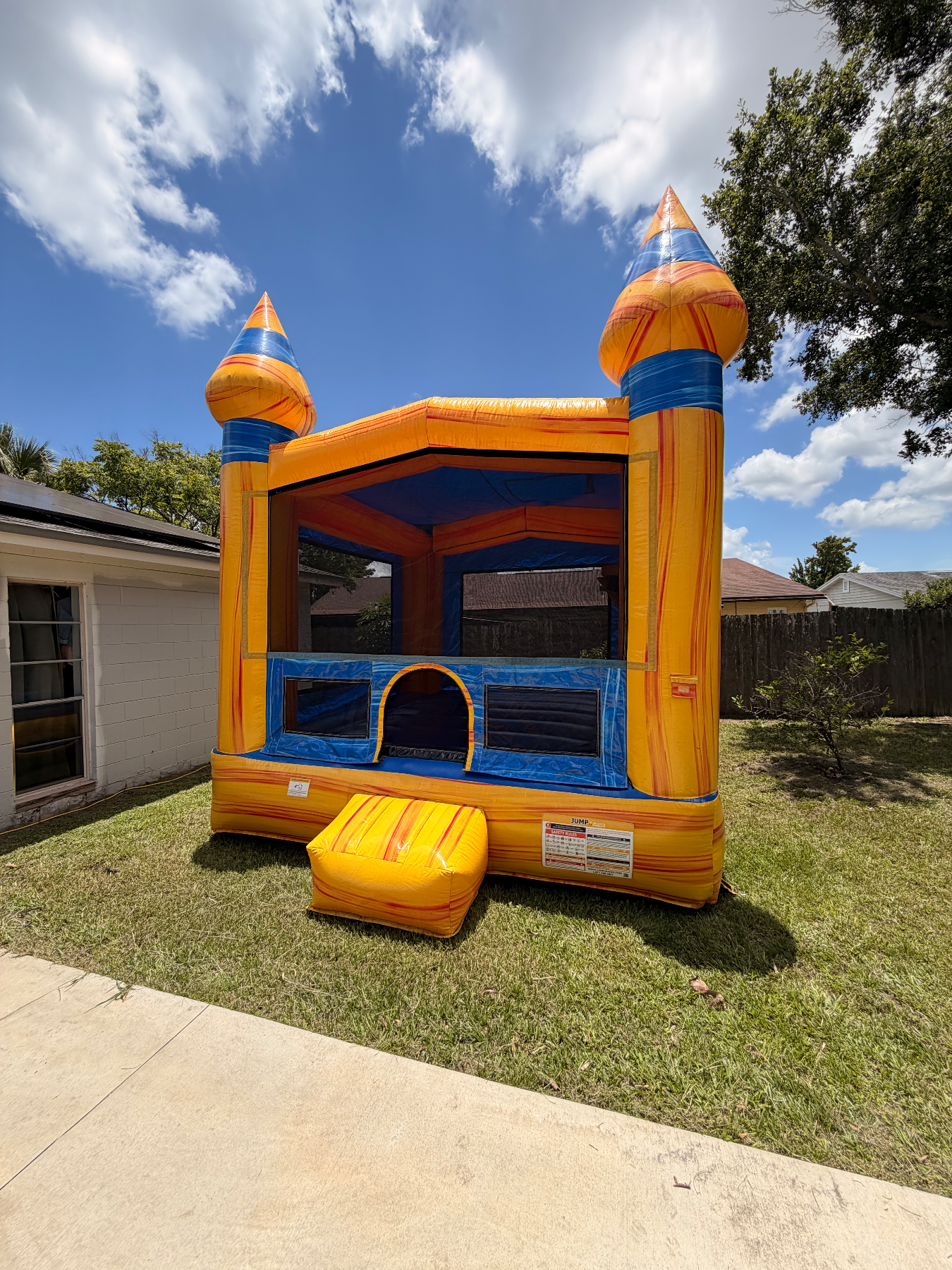 Yellow and blue Volcano castle bounce house with mesh windows and yellow entry step