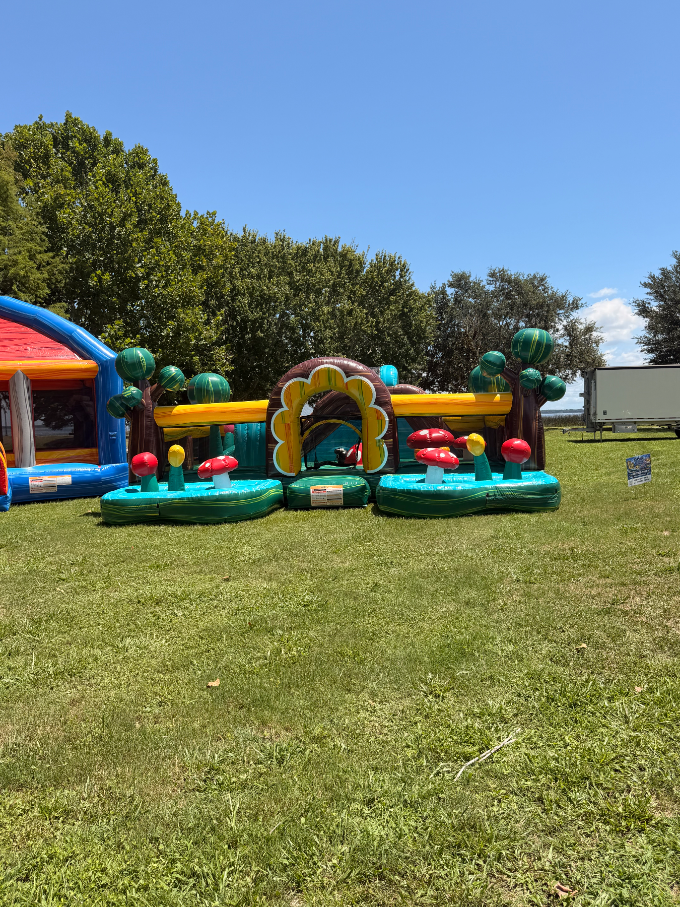 Toddler soft-play inflatable among other party inflatables on a lawn